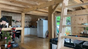 Interior de una cabaña de madera con una cocina, un refrigerador y una mesa de comedor.