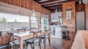 Un interior de madera con comedor, cocina y barra.