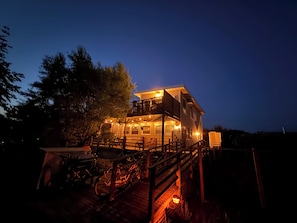 A two-story house with a deck, outdoor seating, and bicycles. - Charming Fair Harbor 3br steps to ocean, sunset view, WiFi, A/C, outdoor shower. (Bay Shore)
