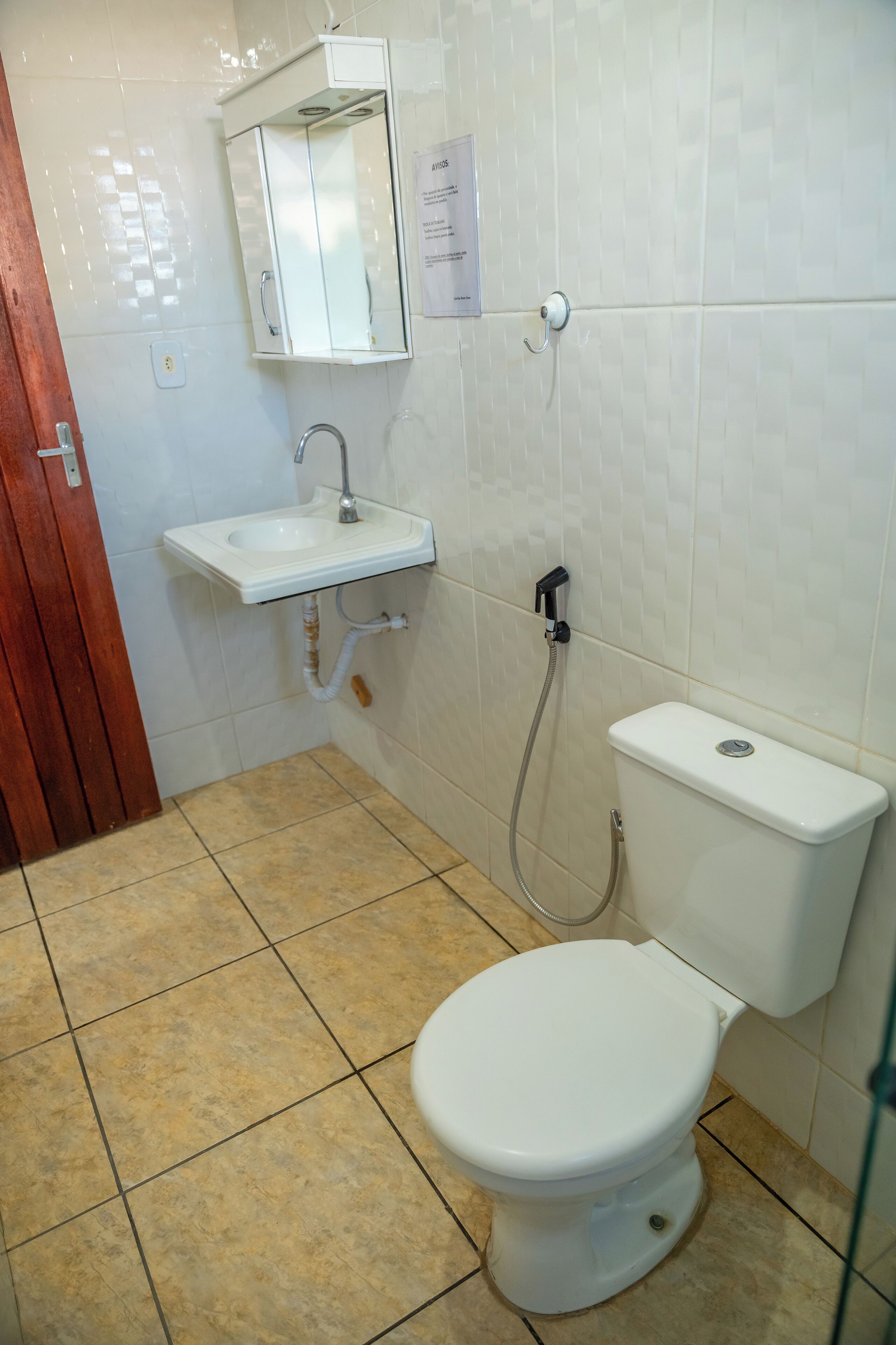 Une salle de bain avec des toilettes, un lavabo et une douche.