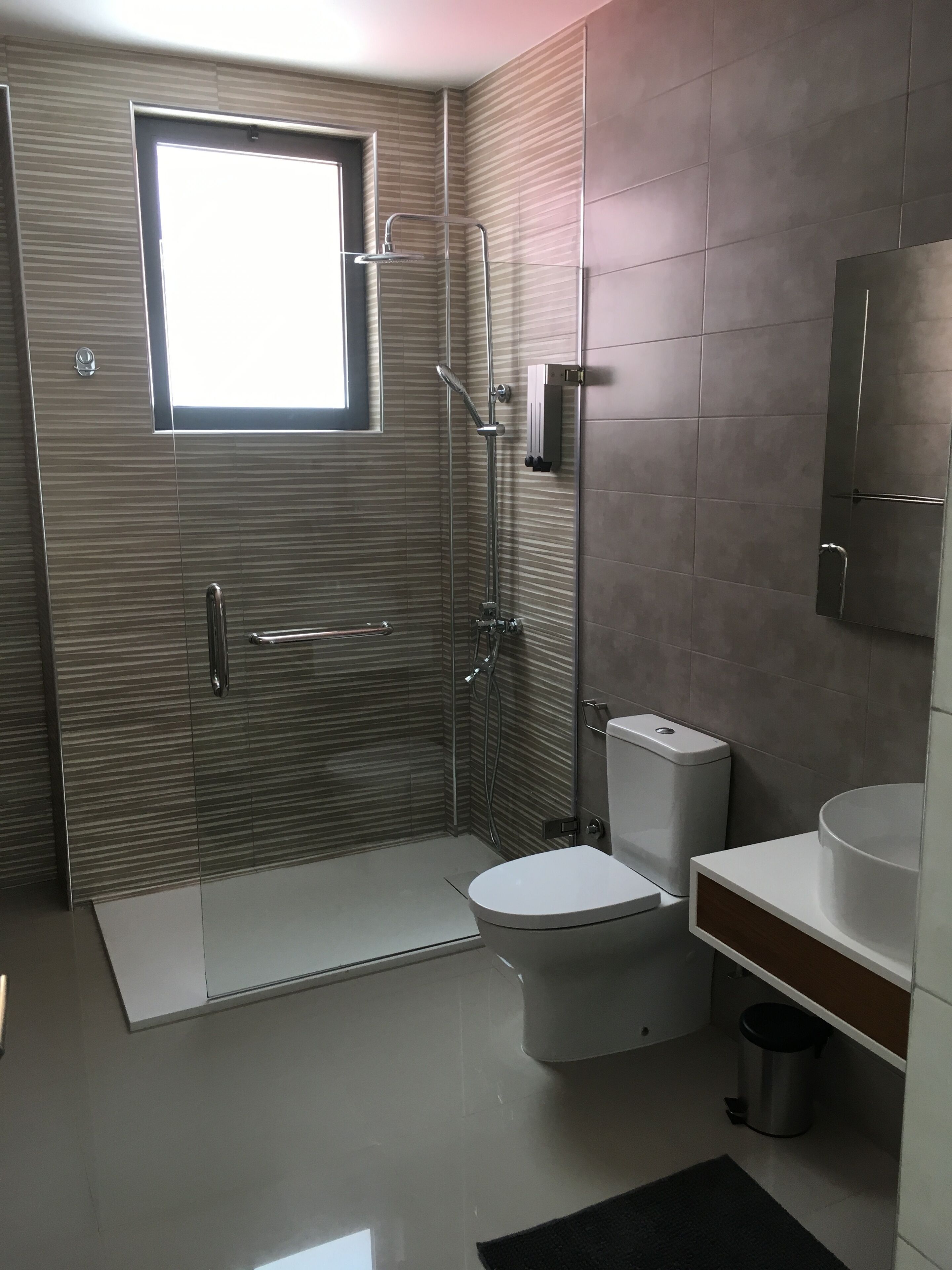 Un baño moderno con ducha, inodoro y lavamanos.
