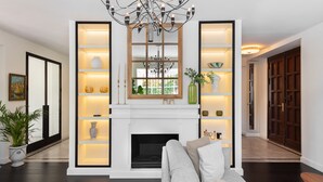 A modern living room with a fireplace, a sofa, and a chandelier.