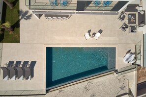 An aerial view of a hotel with a swimming pool, sun loungers, and a covered seating area. - Villa Sunset - Luxury Adriatic Sea View Estate (Podstrana)