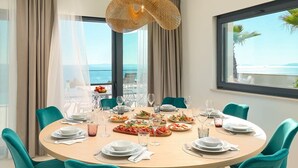 A round dining table with teal chairs, set for a meal with various dishes and glasses. - Villa Sunset - Luxury Adriatic Sea View Estate (Podstrana)