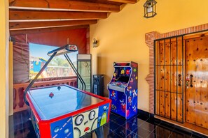 Una habitación con mesa de futbolín, jukebox y un mueble de madera.