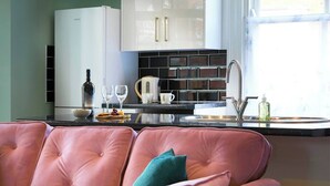 A modern kitchen with a pink leather sofa, a wine bottle, and a coffee maker. - This apartment is a 2 bedroom(s), 1 bathrooms, located in Scarborough, North Yorkshire. (Scarborough)