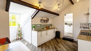 Una cocina con vigas de madera, una ventana, un fregadero y una encimera.