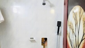 A bathroom with a toilet, a shower, and a door with a decorative glass panel. - Cafe Green Valley (Rangpur)