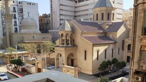 A view of a building with a dome and a bell tower, surrounded by other structures. - Hathor House (Cairo)