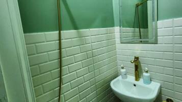 A bathroom with a shower, sink, and mirror.