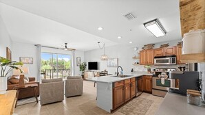 A spacious kitchen with a large island, wooden cabinets, and modern appliances. - Stunning Newly Renovated Poolside Condo Near Beach. Now With Beach Service! (Miramar Beach)