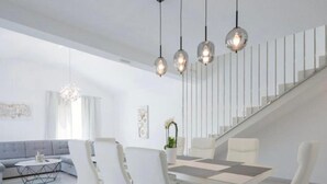 A modern living room with a dining area, a staircase, and a large window. - Villa Rest for the soul - Four Bedroom Villa (Zmijavci)