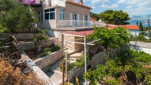 A stone house with a red-tiled roof, a balcony, and a view of the sea. - Holiday Home Aurora - Three bedroom Holiday Home (Postira)