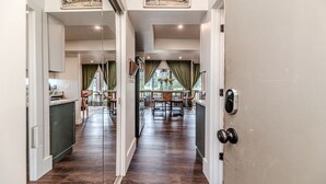 A hallway leading to a dining area with a view of the outdoors.