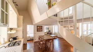 Une cuisine spacieuse avec un coin repas, un escalier et une vue sur l’extérieur.
