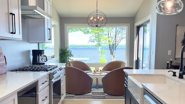 A modern kitchen with a central island, skylights, and a view of the lake. - Green Lake Getaway Lakefront Hot Tub Kayak SUP (Interlochen)
