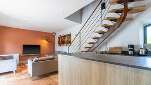 A modern kitchen with a wooden staircase, a flat-screen TV, and a coffee maker. - Holiday Home 'Gite Les Hauts De L'ouysse' with Private Pool, Wi-Fi and Air Conditioning (Lacave)