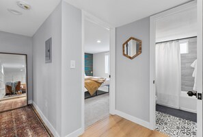 Relax in a serene space with a large mirror, a comfortable bed, and a shower area.