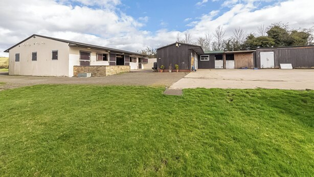 A two-story building with a flat roof, a large open area in front, and a grassy lawn. - 6 bedroom accommodation in Old Quarrington, near Durham (Old Quarrington, near Durham)