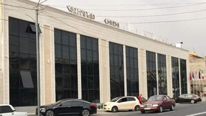 Un bâtiment doté de grandes fenêtres et d’une enseigne au-dessus de l’entrée.