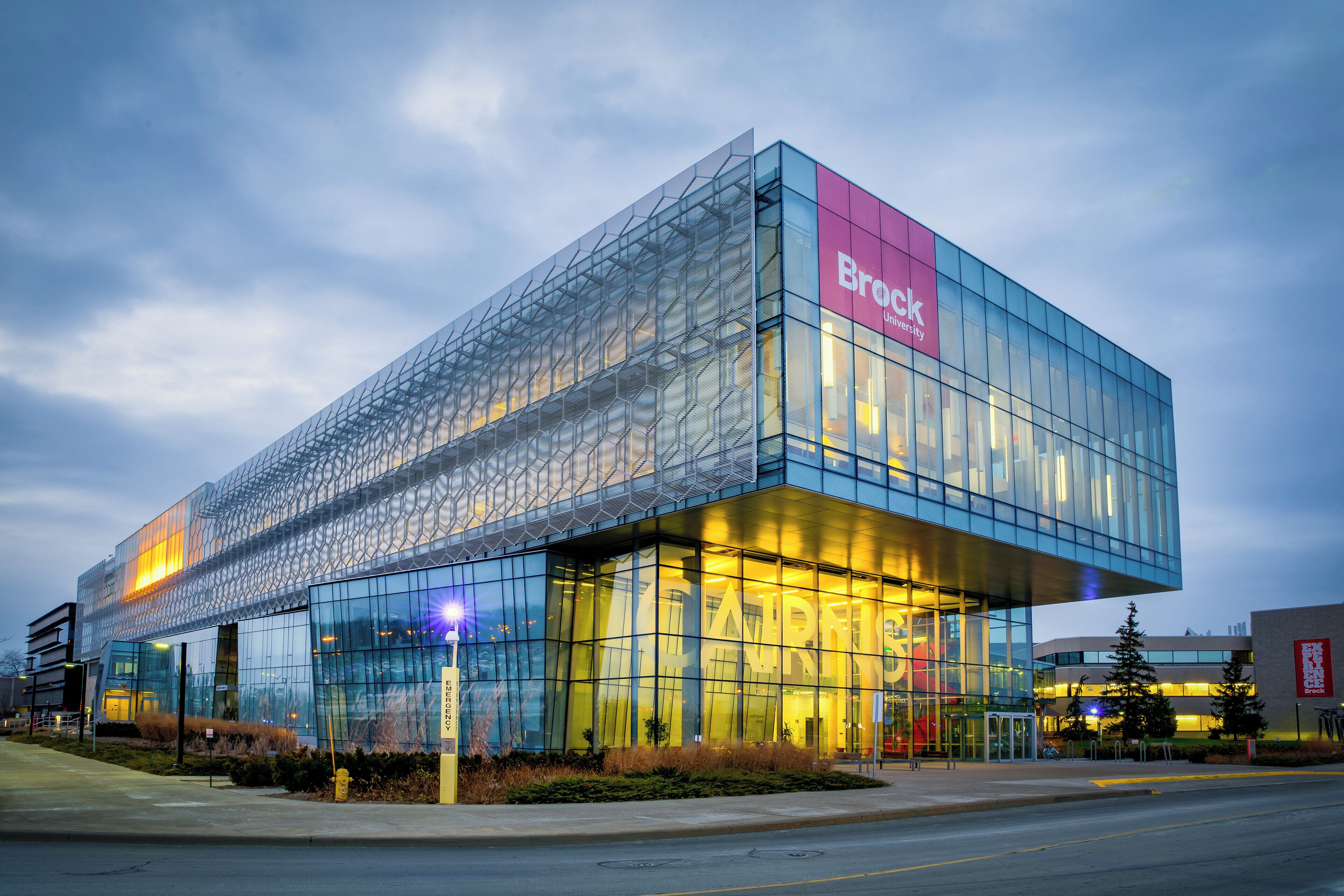 A modern building with a prominent glass facade and a sign reading "Brock University".