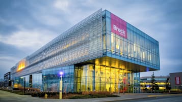 A modern building with a prominent glass facade and a sign reading "Brock University".