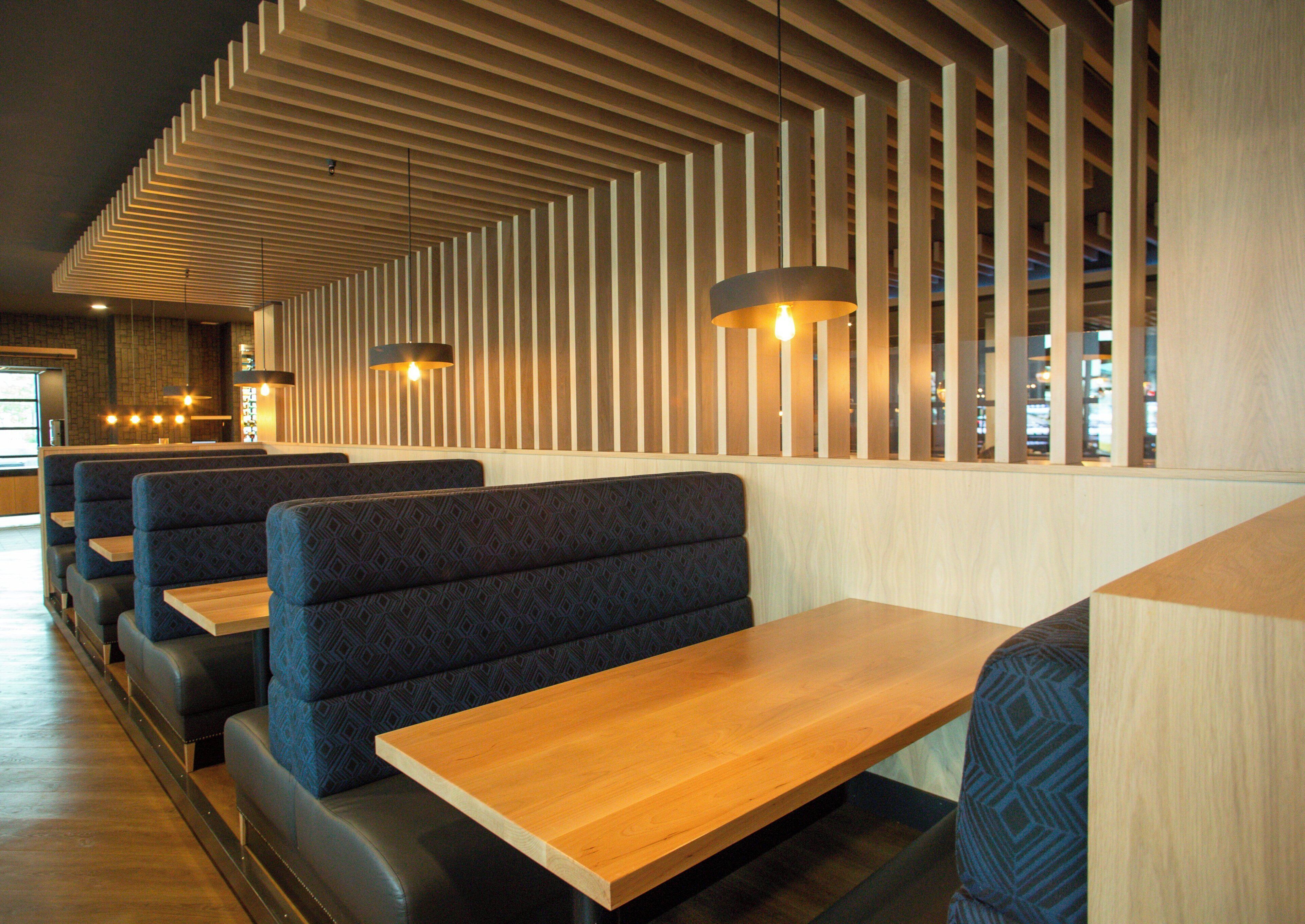 L’intérieur d’un restaurant avec des banquettes et des tables en bois.
