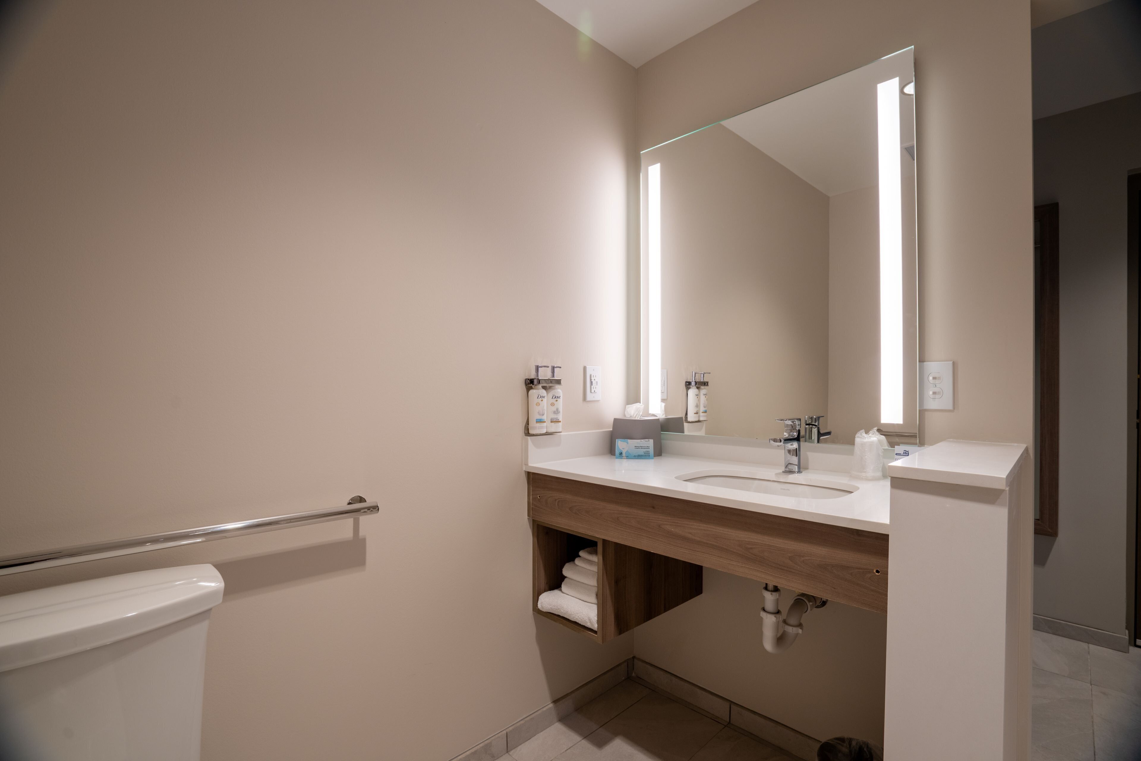 Une salle de bain moderne avec des toilettes, un lavabo et un miroir.