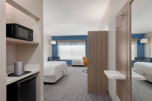A hotel room with a bed, a microwave, a small fridge, a chair, and a wardrobe. - Holiday Inn Express & Suites Prosper South - Frisco by IHG (Prosper)
