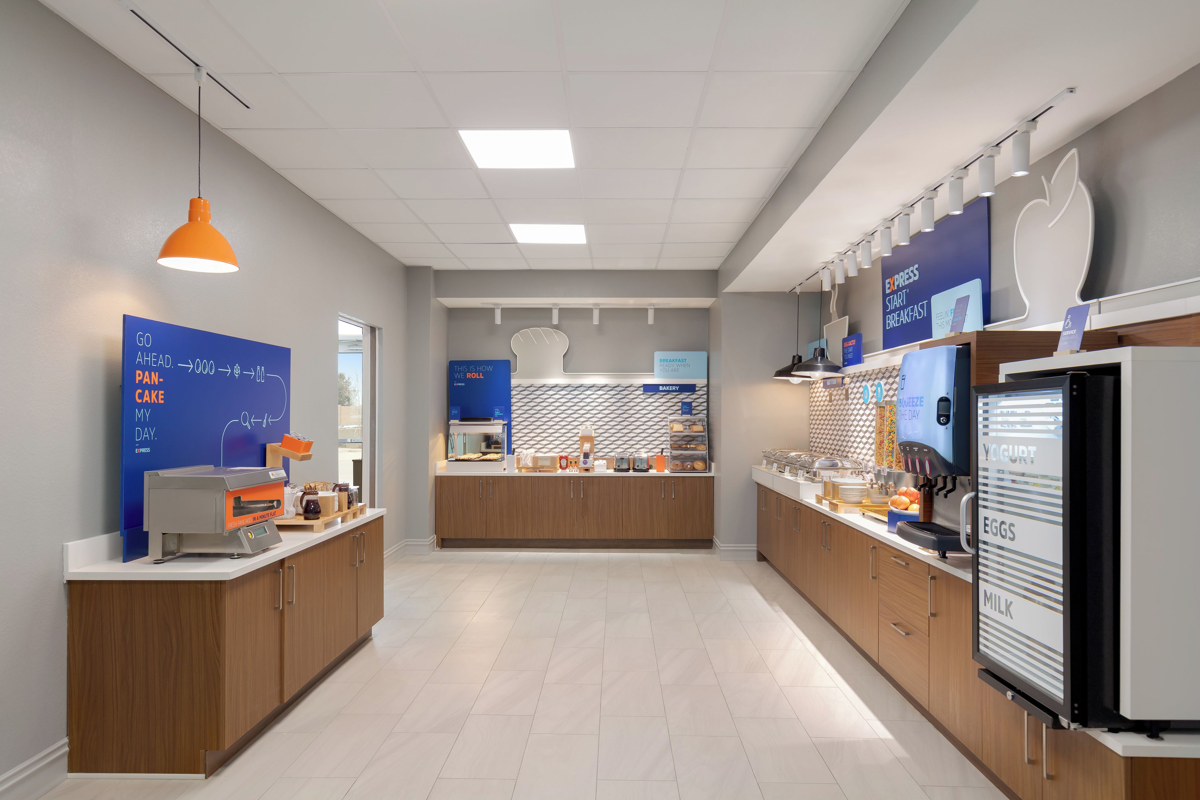 A modern kitchen with a central island, a coffee machine, and a yogurt dispenser.