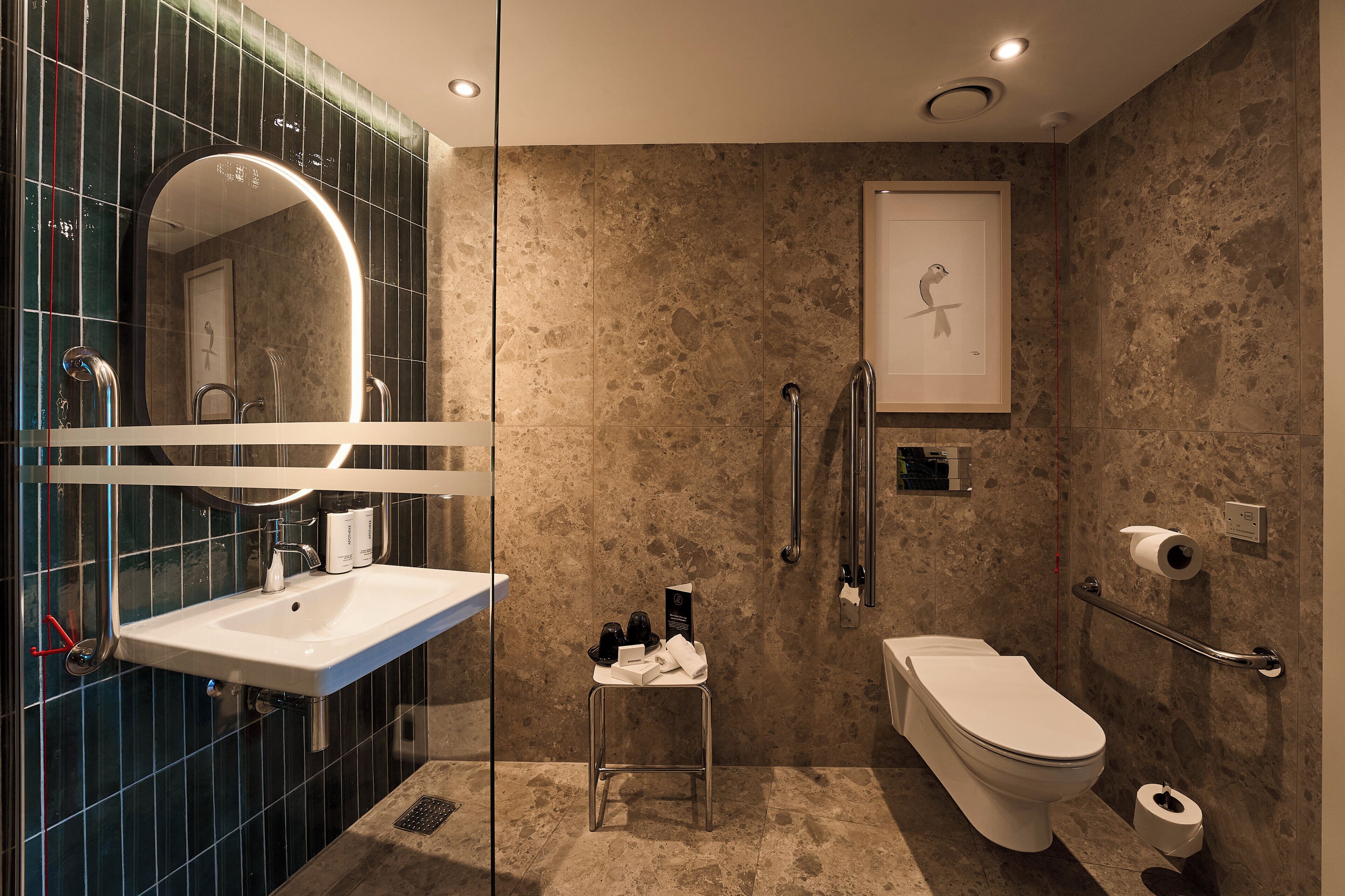 A modern bathroom with a sink, toilet, and shower area.
