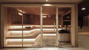 Uma sauna com bancos de madeira e divisória de vidro.
