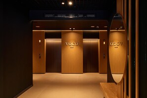 Stylish hallway with three VOCO Malta doors, flanked by wooden panels and recessed lighting.