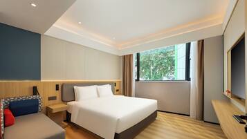 Una habitación de hotel moderna con una cama grande, un sofá, un televisor y una ventana con cortinas.