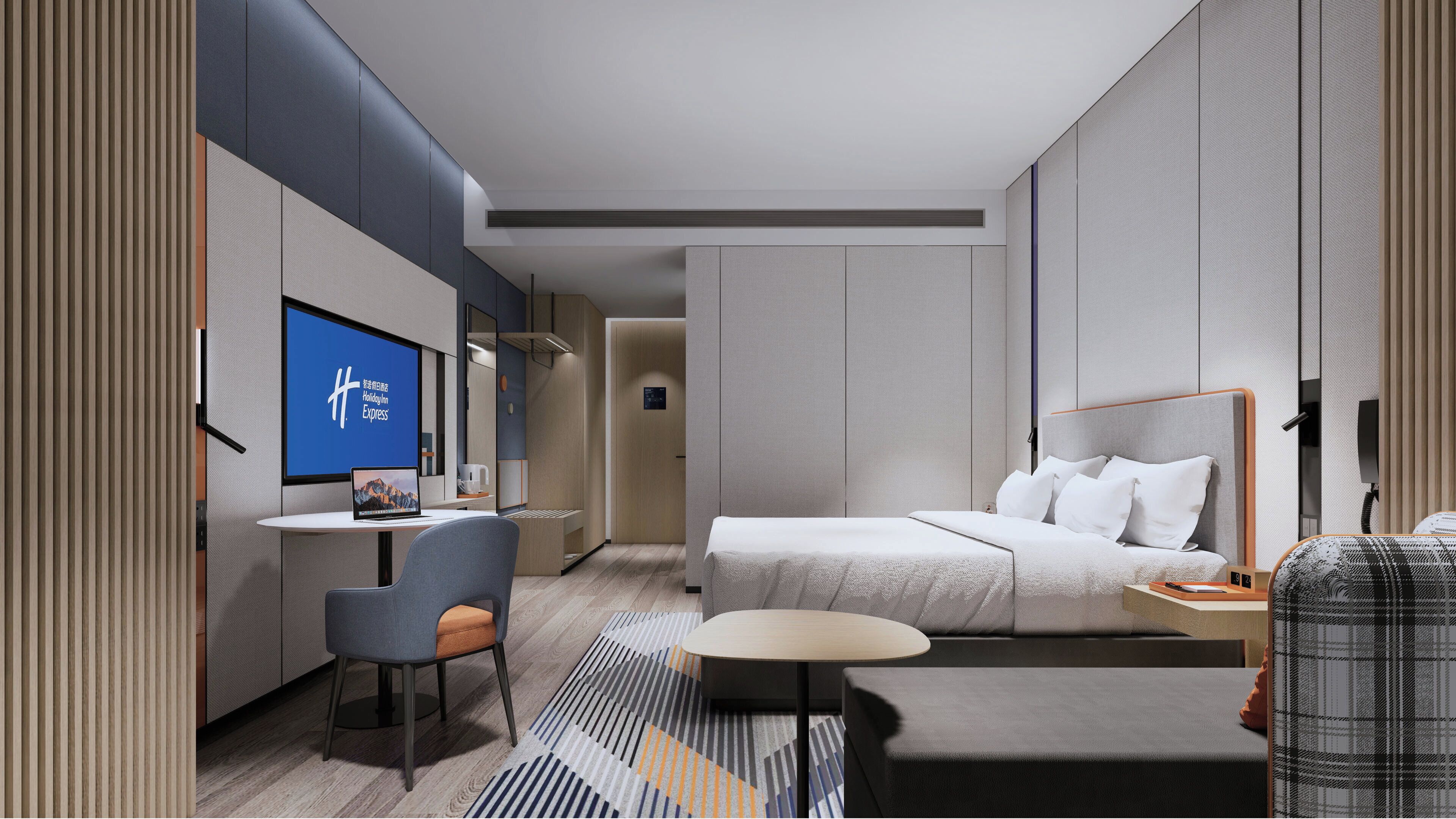 Ein modernes Hotelzimmer mit Bett, Schreibtisch, Stuhl und einem Fernseher mit dem Holiday Inn Express Logo.