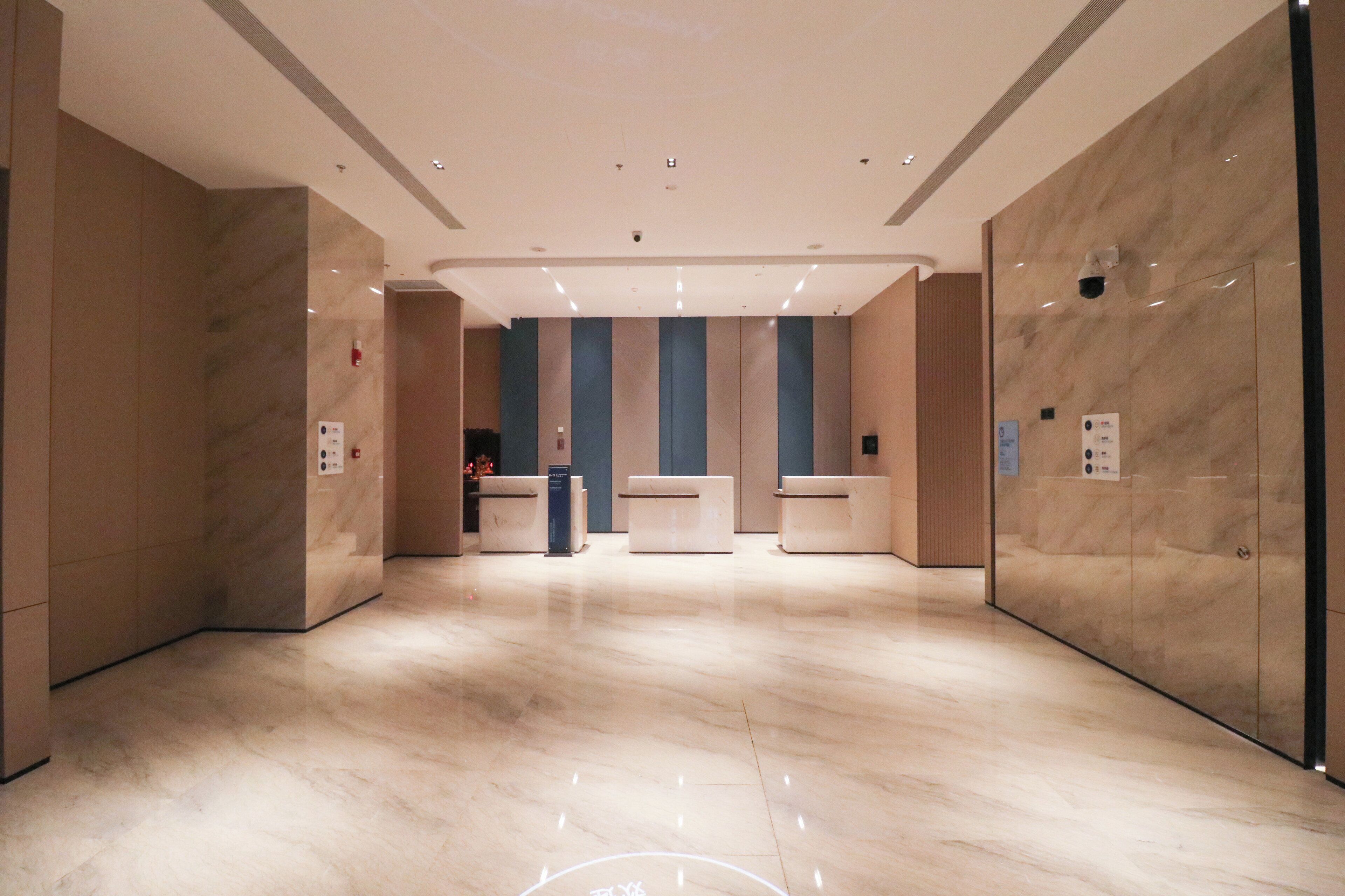 Eine großzügige Lobby mit Marmorboden, einer Rezeption und einem modernen Deckenstil.