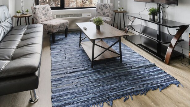 Una sala de estar moderna con un sofá, sillones, una mesa de centro y un televisor.