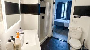 A bathroom with a white sink, a mirror, a shower, and a toilet. - 2BR apt near EWR airport 7xw8 (Elizabeth)