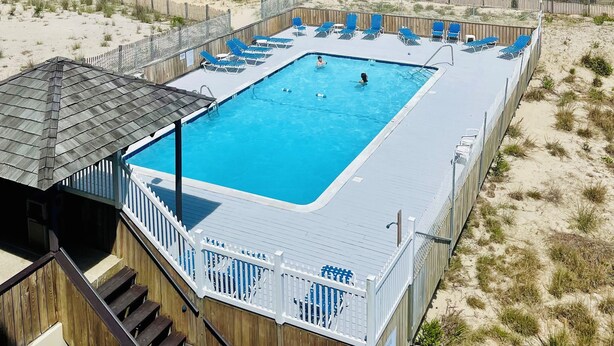 Zona de piscina con vista a la playa y al océano.