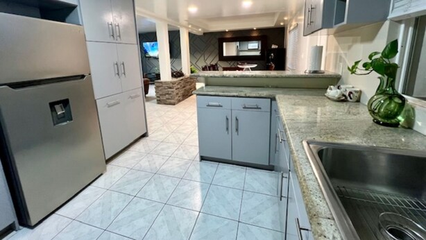 A modern kitchen with grey cabinets, a built-in oven, and a stainless steel sink. - CASA LIBERTAD 854 (Tijuana)