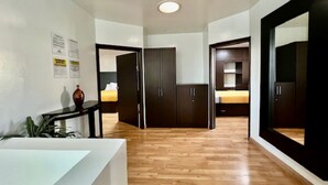 A hotel corridor with wooden flooring, a reception desk, and dark wooden wardrobes. - CASA LIBERTAD 854 (Tijuana)