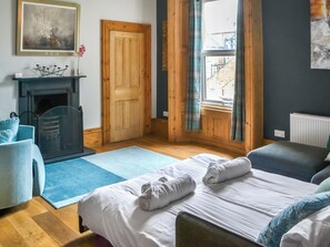 A hotel room with a bed, a chair, a fireplace, and a view of the outside.