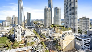 Ein hoch aufragendes Hotel mit modernem Design, das mehrere Balkone und einen markanten Uhrturm aufweist.