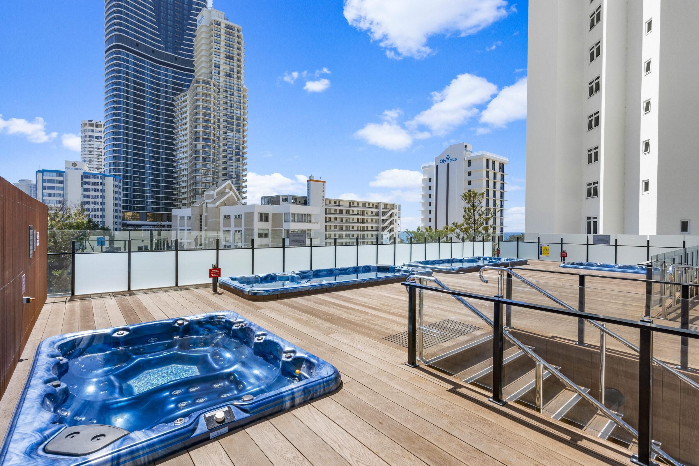 A rooftop deck with hot tubs and a city view.