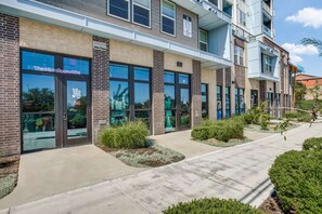 Stylish building with a brick facade and large glass windows, set amidst well-maintained landscaping.