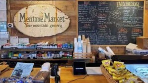 A grocery store interior with a sign reading "Mentone Market - Your mountain grocery".