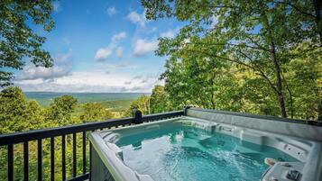 Un jacuzzi con vistas panorámicas de un paisaje boscoso.