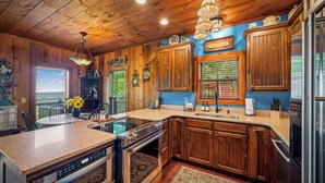 A kitchen with wooden cabinets, a granite countertop, a built-in oven, and a stainless steel dishwasher.