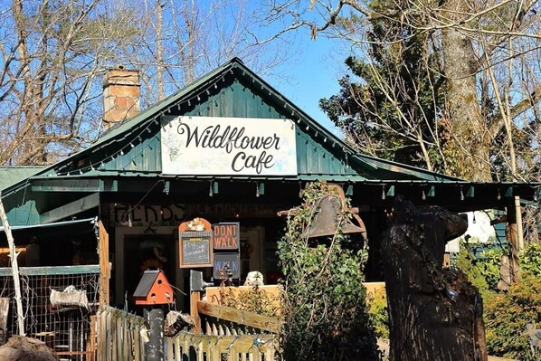 Un edificio rústico con techo verde, con la leyenda 'Wildflower Cafe'.