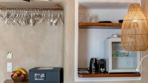 A kitchen with a fruit bowl, a coffee maker, and a refrigerator.